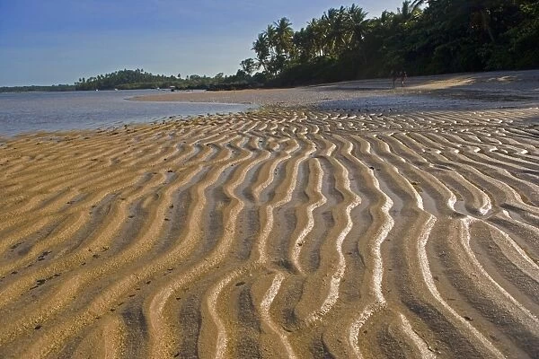 Low tide exposes wave sculpted patterns in the sand
