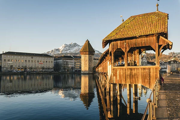 Lucerne, Switzerland. KapellbrAocke (Chapel Bridge) on Reuss river and mount Pilatus