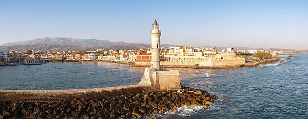 Majestic lighthouse overlooking the old harbour and colorful town of Chania, Crete
