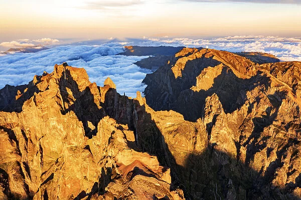 Majestic mountains of Pico das Torres and Pico do Arieiro lit by sunset, aerial view