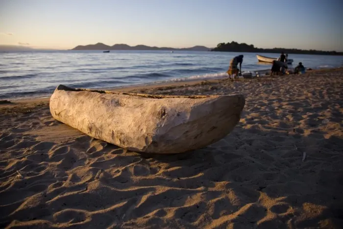 Framed Print : Malawi, Monkey Bay. An old dug-out canoe pulled up on to the beach of Lake Malawi