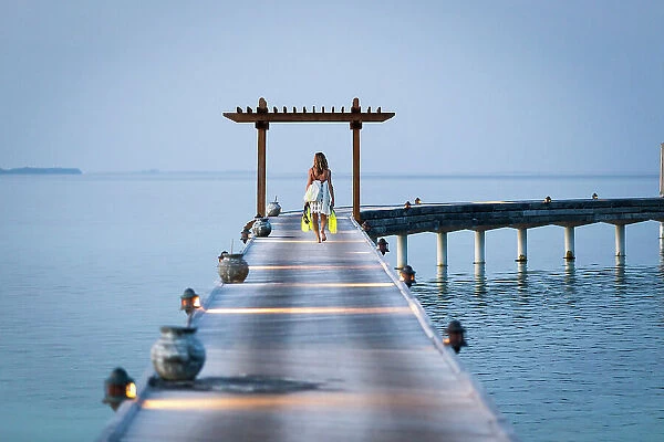 Maldives, Ari Atoll, Moofushi Resort, A tourist walks on the deck to Water Willas