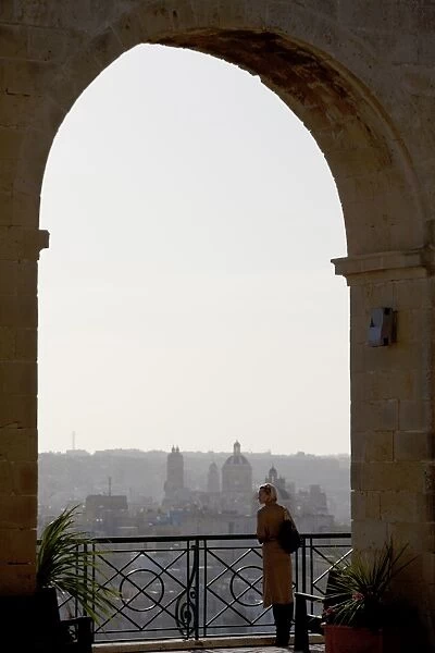 Malta, Europe; A tourist enjoying the scenery of the three cities from the Upper Barracca Gardens in