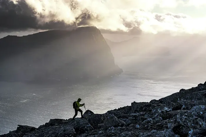 Framed Print : Man with backpack climbing a mountain above the fjord lit by sun rays at sunset, Vidoy Island, Faroe Islands (MR) Framed Print : Man with backpack climbing a mountain above the fjord lit by sun rays at sunset, Vidoy Island, Faroe Islands (MR)