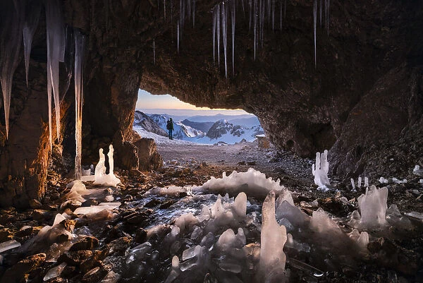 A man at Grotta dei Pagani with stalactites and stalagmites, Castione della Pesolana, Prealpi Orobie, Bergamo, Lombardy, Italy (MR)
