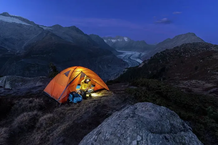 Framed Print : Man with head torch preparing meals outside the tent pitched above the Aletsch glacier at dusk, Bernese Alps, Valais canton, Switzerland (MR) Framed Print : Man with head torch preparing meals outside the tent pitched above the Aletsch glacier at dusk, Bernese Alps, Valais canton, Switzerland (MR)