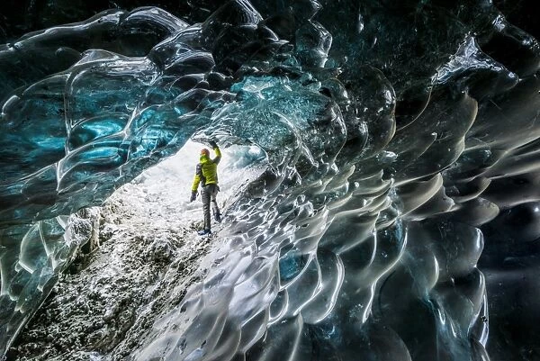 Man inside an ice caver under the Vatnajokull glacier, Vatnajokull national park