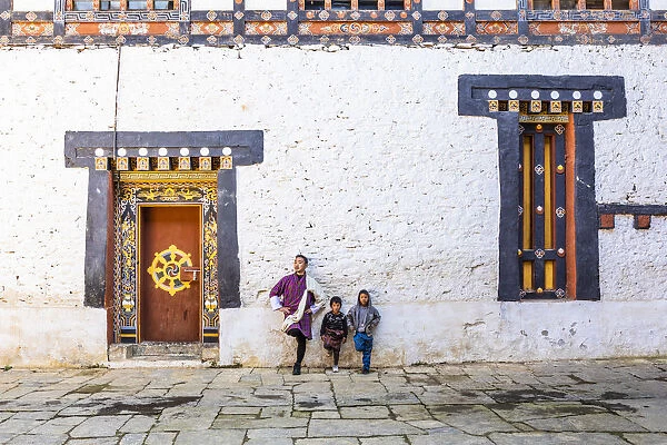 A man and kids standing in Trongsa Dzong, Trongsa District, Bhutan