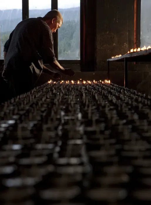 Framed Print : A man lighting candles in a temple in Bhutan Framed Print : A man lighting candles in a temple in Bhutan