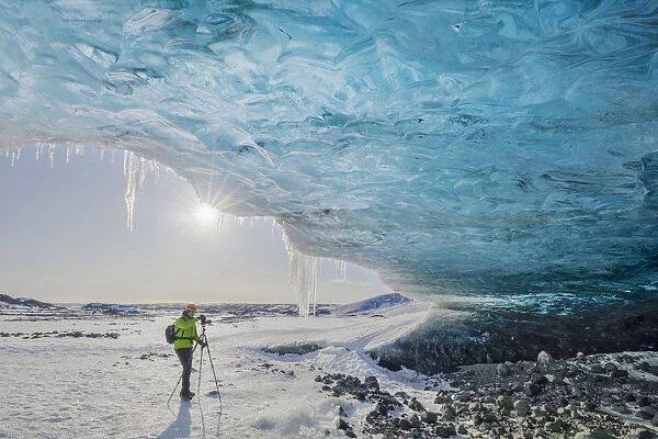 Man photographs an ice cave of Breidamerkurjokull, Austurland, Iceland