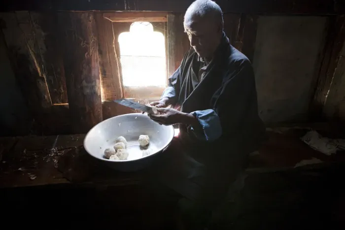 Framed Print : A man preparing potatos in the manufacture of arra in Ura in the Bumthang, Valley Framed Print : A man preparing potatos in the manufacture of arra in Ura in the Bumthang, Valley