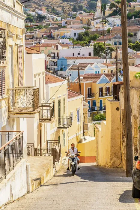 Framed Print : A man riding a scooter in Symi, Dodecanese Islands, Greece Framed Print : A man riding a scooter in Symi, Dodecanese Islands, Greece