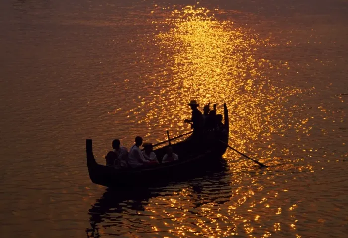Framed Print : A man rows a local wooden boat across the Irrawaddy River at sunset Framed Print : A man rows a local wooden boat across the Irrawaddy River at sunset