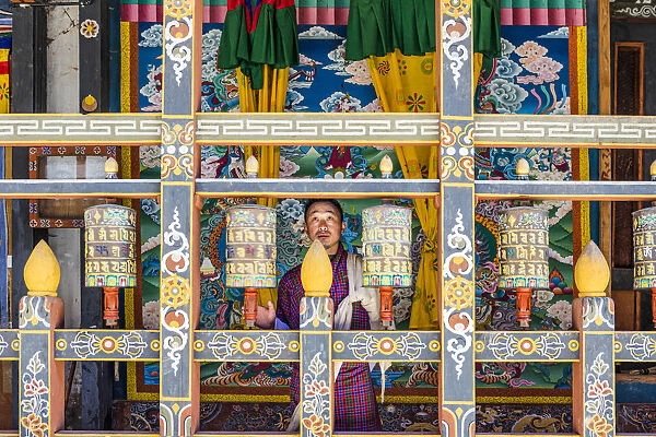 A man spinning prayer wheels in Trongsa Dzong, Trongsa District, Bhutan