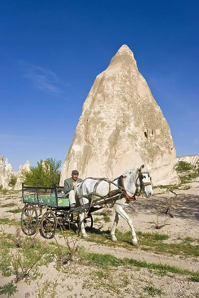 Man using traditional transport, Tufa rock formations, Rose Valley, nr Goreme, Cappadocia
