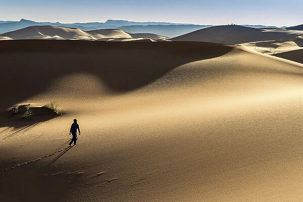 Man walking on the Erg Chebbi dunes in the Sahara Desert, Merzouga, Morocco