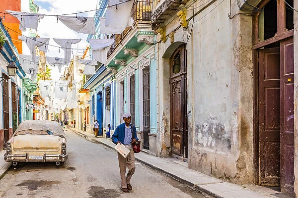 A man walking in a narrow street in La Habana Vieja (Old Town), Havana, Cuba