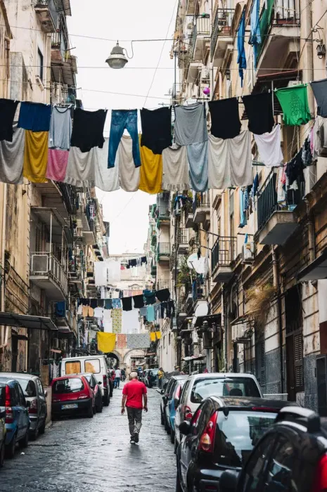 Framed Print : Man walks in an alley in Naples, with clothes hanging between the buildings Framed Print : Man walks in an alley in Naples, with clothes hanging between the buildings