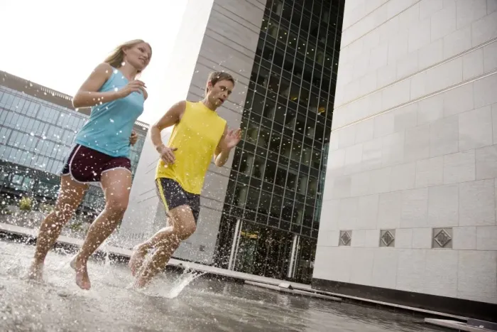Framed Print : A man and woman running barefoot through water