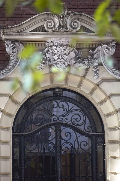 Detail of a mascaron ornament on the main facade of a building in Art Nouveau style