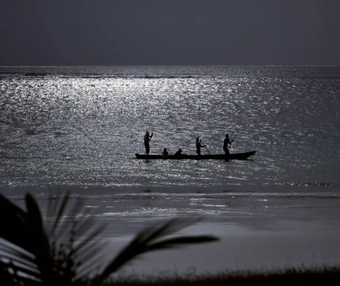 Framed Print : Three men pole a dugout canoe by moonlight in shallow water along Diani Beach Framed Print : Three men pole a dugout canoe by moonlight in shallow water along Diani Beach