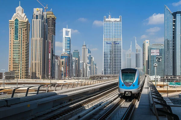 Metro train with city skyline in the background, Dubai, United Arab Emirates