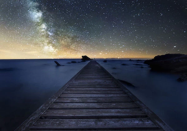 Milky way over an old pier near Livorno in Tuscany, Italy