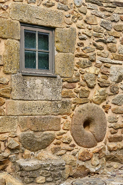 A millstone on the wall of a traditional house. Castelo Rodrigo, Beira Alta. Portugal
