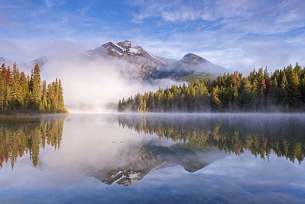 Mist obscures Pyramid Mountain, reflected in Pyramid Lake in the Canadian Rockies