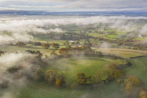 Misty autumn morning above Cadbury Castle Iron Age Hillfort, Cadbury, Devon, England