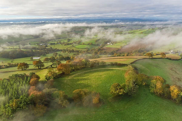 Misty morning over Cadbury Castle Hillfort in Devon, England. Autumn (November) 2021