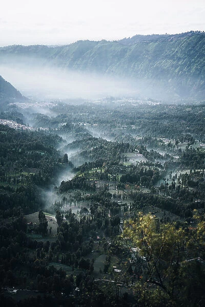 Misty morning by the Mount Bromo, landscape and town by the Volcano
