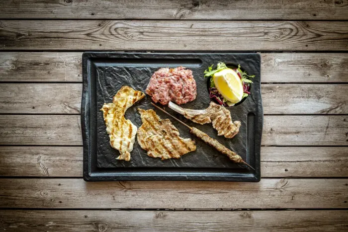 Framed Print : Mixed grilled meat in black tray on rustic wood table background from above, Italy Framed Print : Mixed grilled meat in black tray on rustic wood table background from above, Italy
