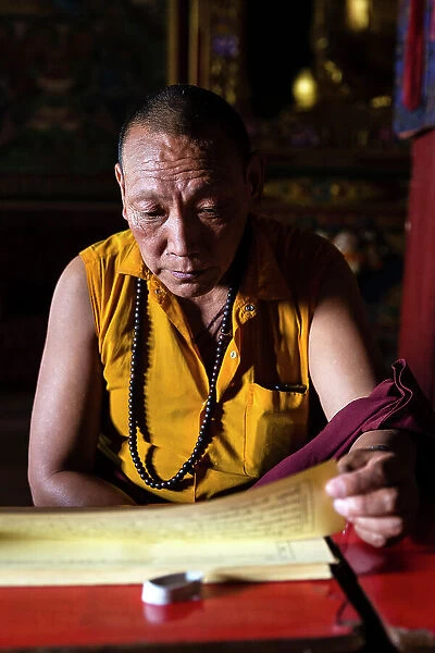 Monk reading sacred texts in monastery at Boudhanath, Kathmandu, Nepal