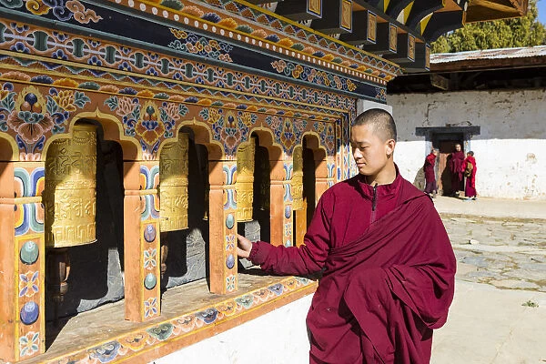 A monk spinning prayer wheels in Gangteng Monastery, Phobjikha Valley, Bhutan