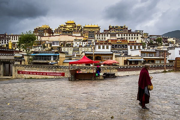 Monk walking in front at the Ganden Sumtseling Monastery, Zhongdian, Shangri-La County