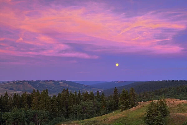 Full moon at sunset from Reesor Lake VIewpoint Cypress Hills Provincial Park, Alberta, Canada