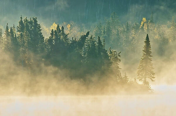 Morning fog rises over a northern lake in the boreal forest Near White Lake Ontario, Canada