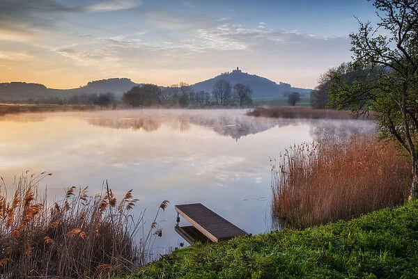 Morning mist over pond with Wachsenburg castle in the background