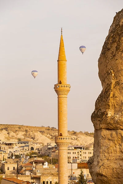 Mosques minaret and hot air balloons in the sky of Goreme
