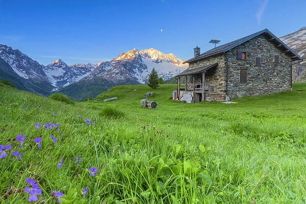 Mountain house at Alpe dell Oro with Mount Disgrazia in the background. Chiareggio