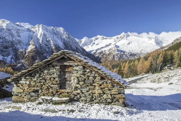 Framed Print : A mountain hut surrounded by snow capped peaks and colorful woods in autumn at Alp Entova Framed Print : A mountain hut surrounded by snow capped peaks and colorful woods in autumn at Alp Entova