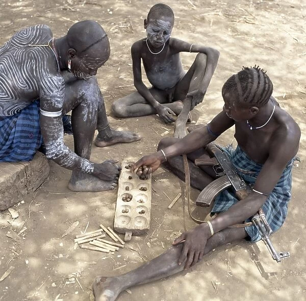 Two Mursi men with singular hairstyles play a game