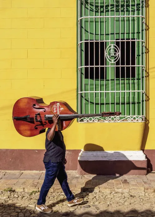 Framed Print : Musician with his double bass walking through the colourful street of Trinidad Framed Print : Musician with his double bass walking through the colourful street of Trinidad