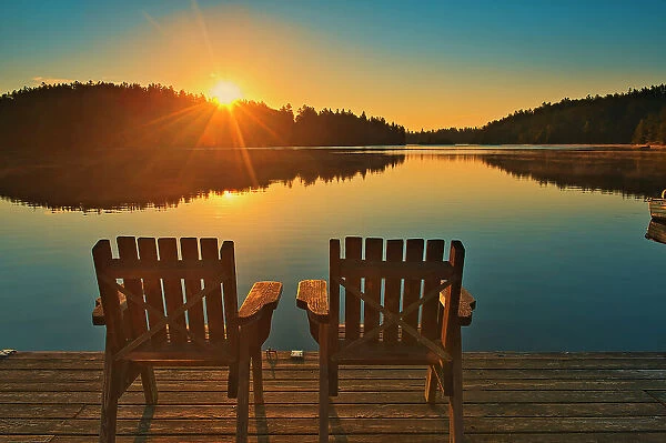 Muskoka chairs on Snake Island Lake (Cassels Lake) at sunrise Temagami, Ontario, Canada