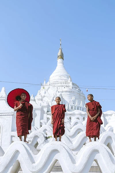 Myanmar, Mandalay division, Mingun. Three novice buddhist monks standing on Hsinbyume
