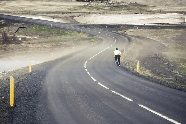 Myvatn district, northern Iceland. Man cycling on the road through the fog