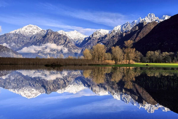 The natural reserve of Pian di Spagna flooded with snowy peaks reflected in the water