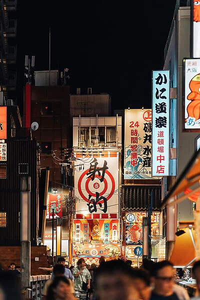 Neon lights and crowd in the streets of Osaka by night, Japan