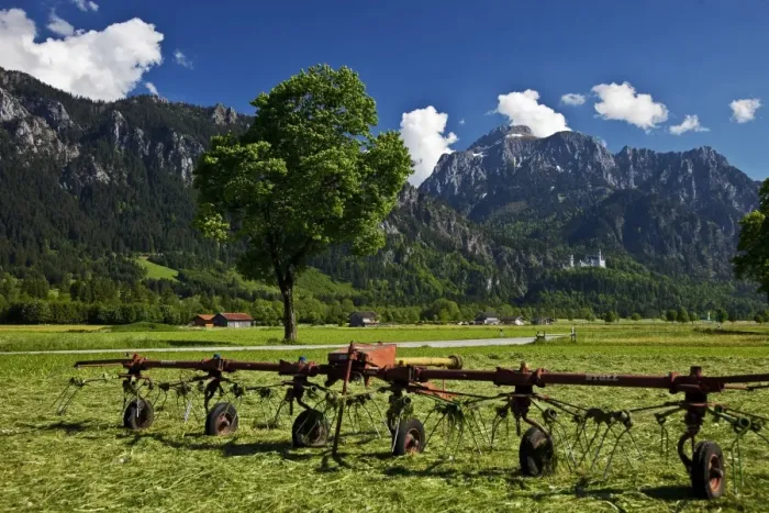 Framed Print : Neuschwanstein Castle in the distance with Farming equipment in the foreground Framed Print : Neuschwanstein Castle in the distance with Farming equipment in the foreground